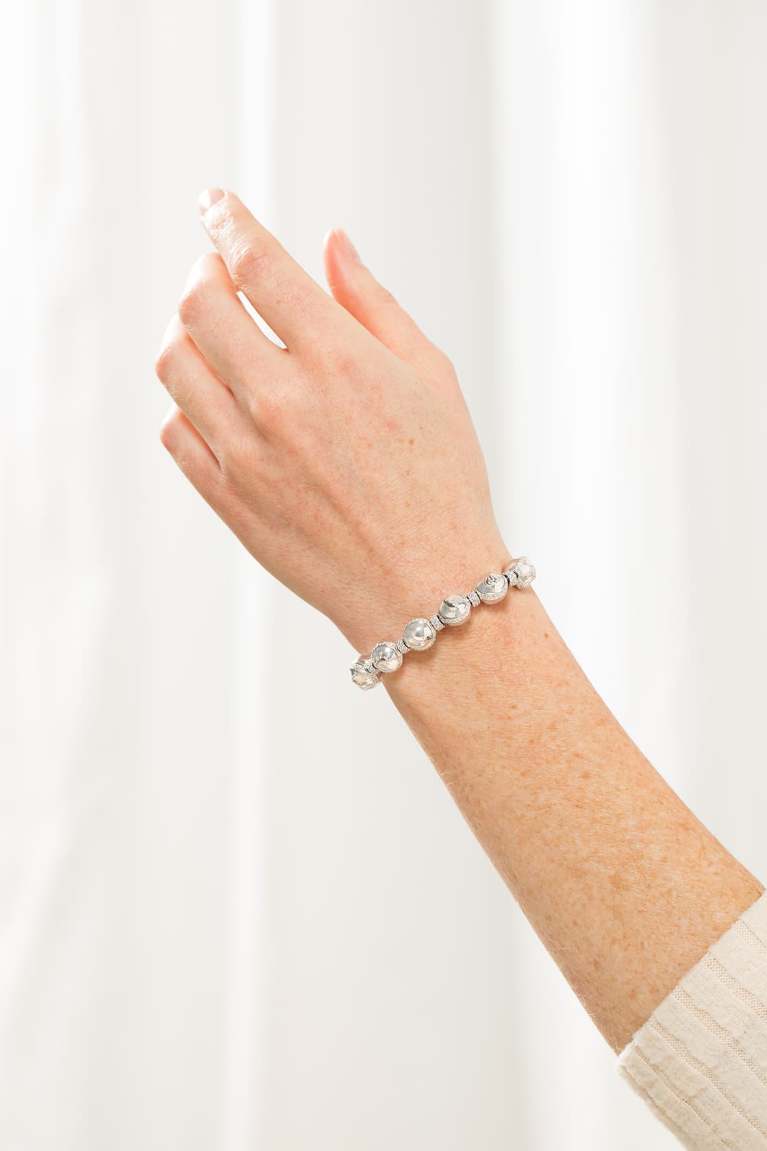 Silver Charmed Beginnings pregnancy charm bracelet worn on the wrist