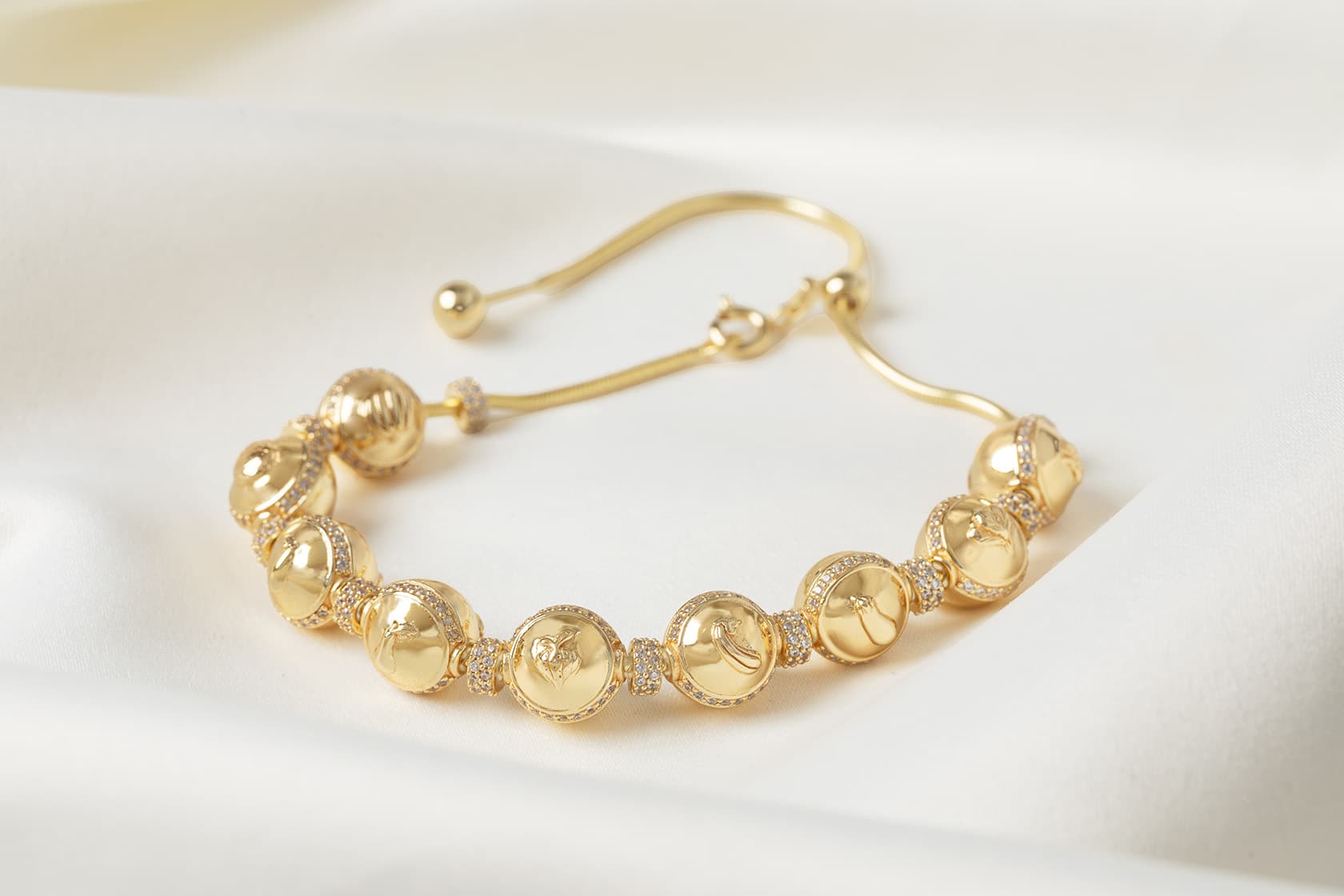Gold-tone pregnancy charm bracelet lined with milestone charms